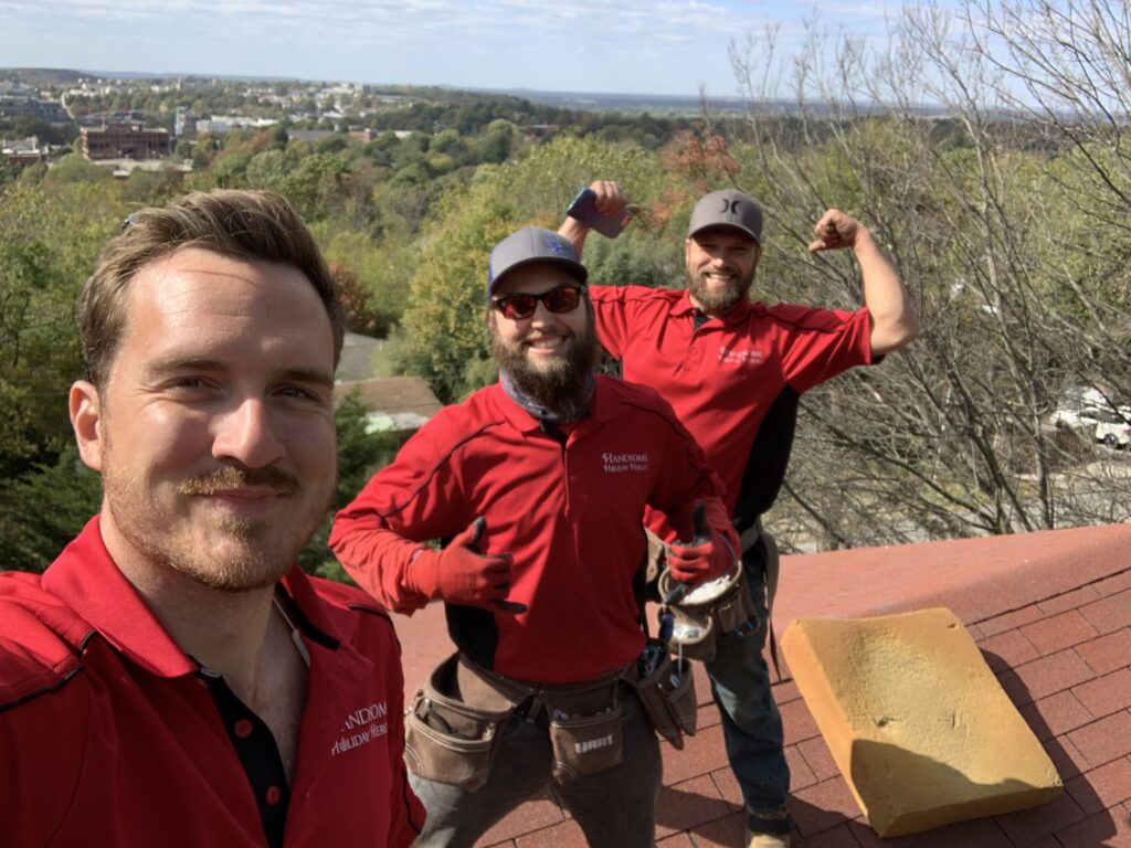 Professional Christmas light installers. Handsome Holiday Heroes hard at work on a roof